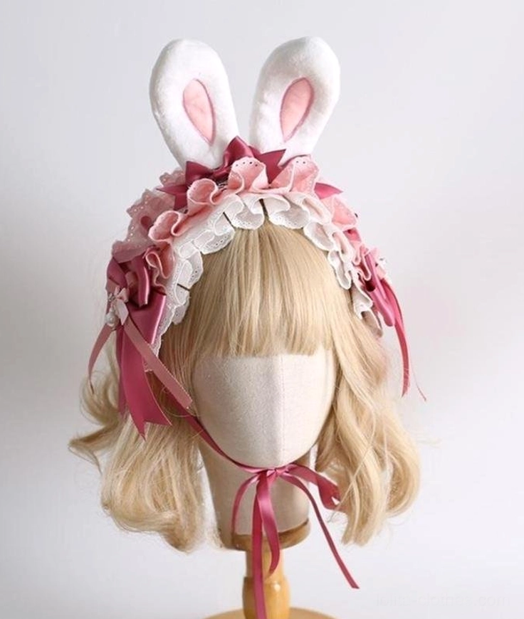 Sweet lolita bunny ear hair clips with fancy bow hairband front three-quarter view on blonde bob mannequin featuring fluffy white ears pink inner panels ruffled lace trim and dark pink satin bows