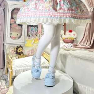 Sweet Lolita bunny ear platform Mary Jane shoes in baby blue glossy patent leather, low three-quarter angle view showing ankle buckle strap and bow vamp ornament, bedroom display