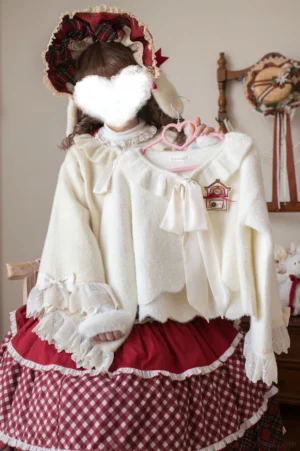 Cream-colored sweet lolita winter cardigan with peter pan collar and detachable bow pin, featuring ruffled lace cuffs and heart-shaped buttons on model styled in vintage home setting