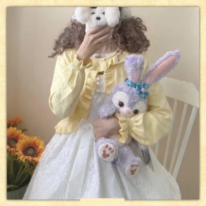 Yellow sweet lolita cotton cardigan with ruffled collar and hollow cherry pattern, modeled with white skirt and Stellalou plush toy