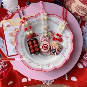 Sweet Lolita dessert necklace flat lay with popcorn cake and cherry tomato pendants on floral porcelain plate