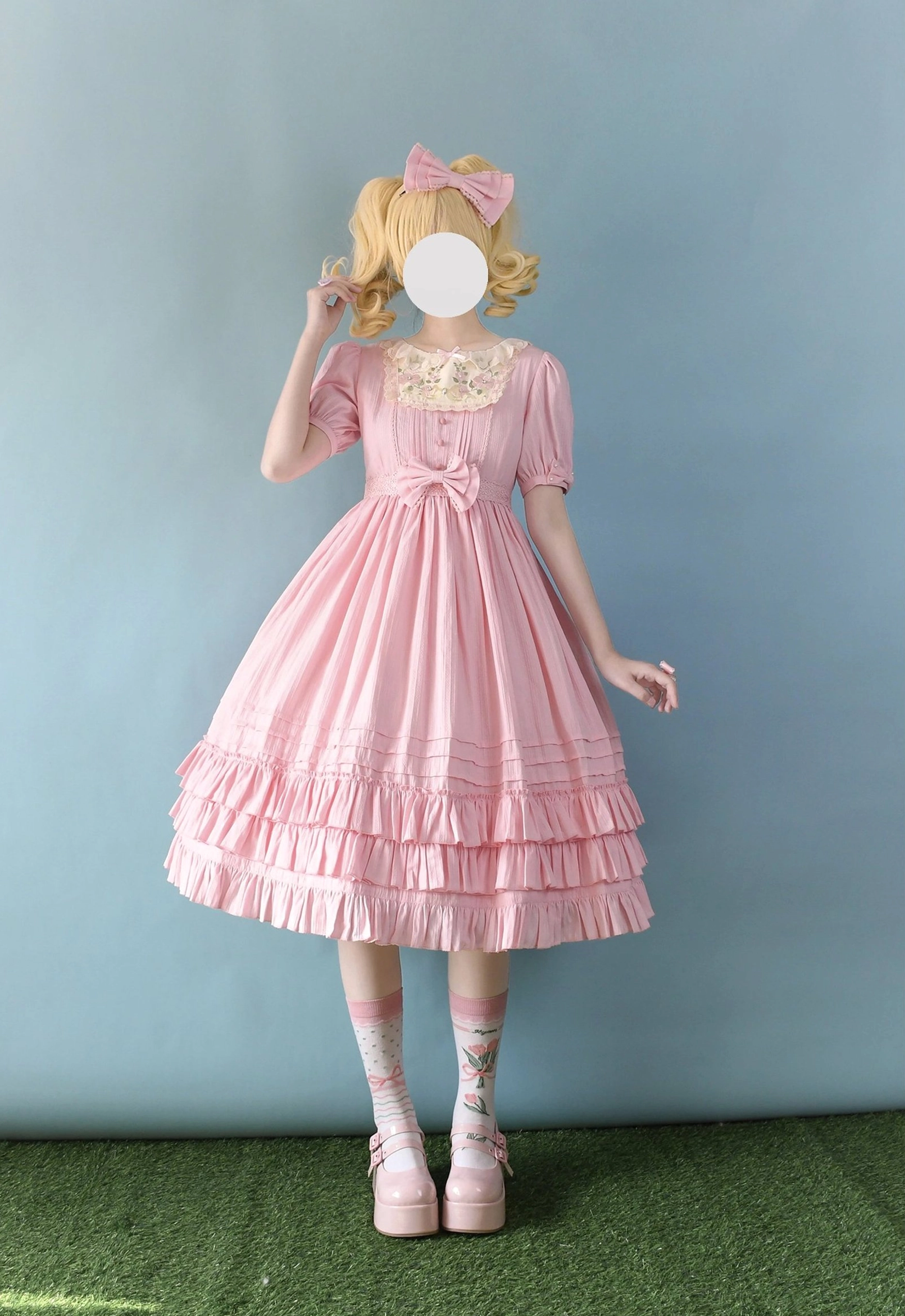 Soft pink Sweet Lolita embroidered OP dress with short puff sleeves, lace embroidered collar, tiered ruffled midi skirt, front waist bow, styled with printed socks and pink Mary Jane shoes, full-body view