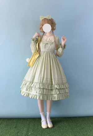 Sage green Sweet Lolita embroidered OP dress featuring long puff sleeves, square embroidered lace neckline, multi-layer ruffled skirt, waist bow decoration, modeled with yellow crossbody bag and light yellow Mary Jane shoes