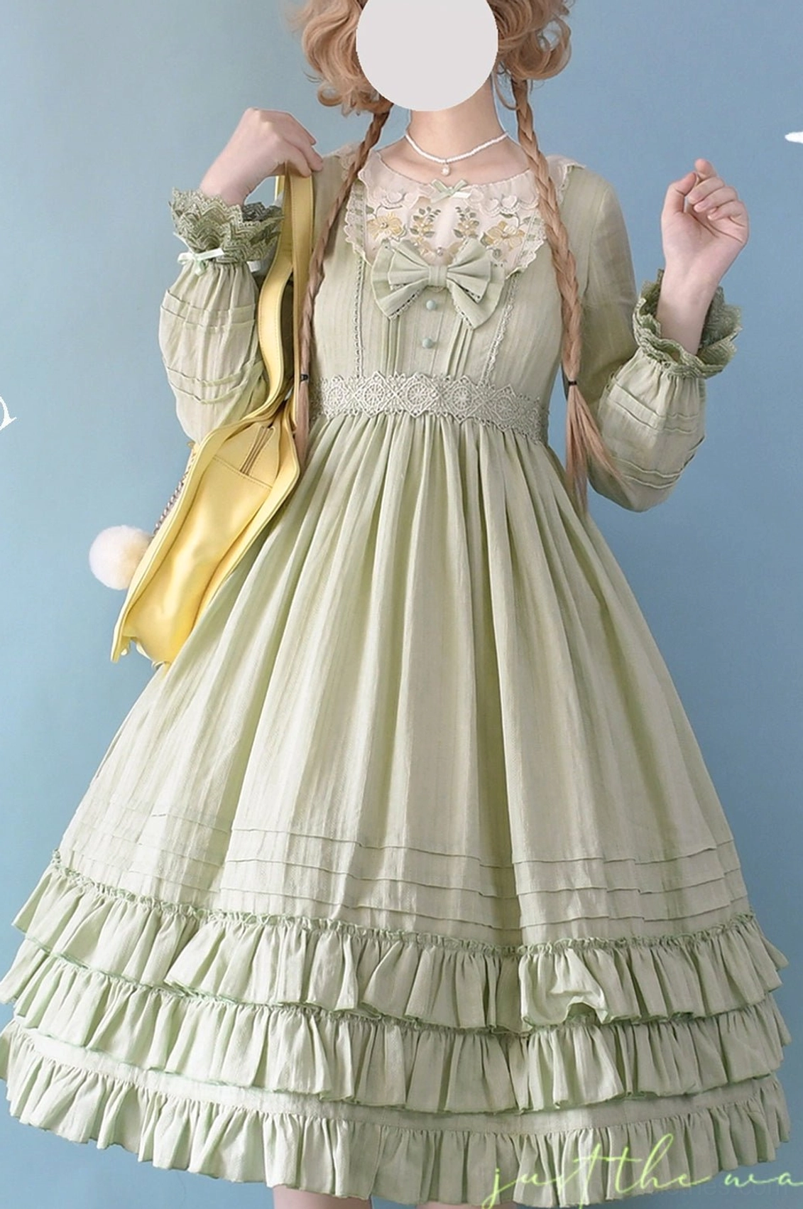 Sage green Sweet Lolita embroidered OP dress half-body front view with long puff sleeves, square embroidered lace neckline, waist bow, ruffled tiered midi skirt, paired with yellow crossbody bag styling