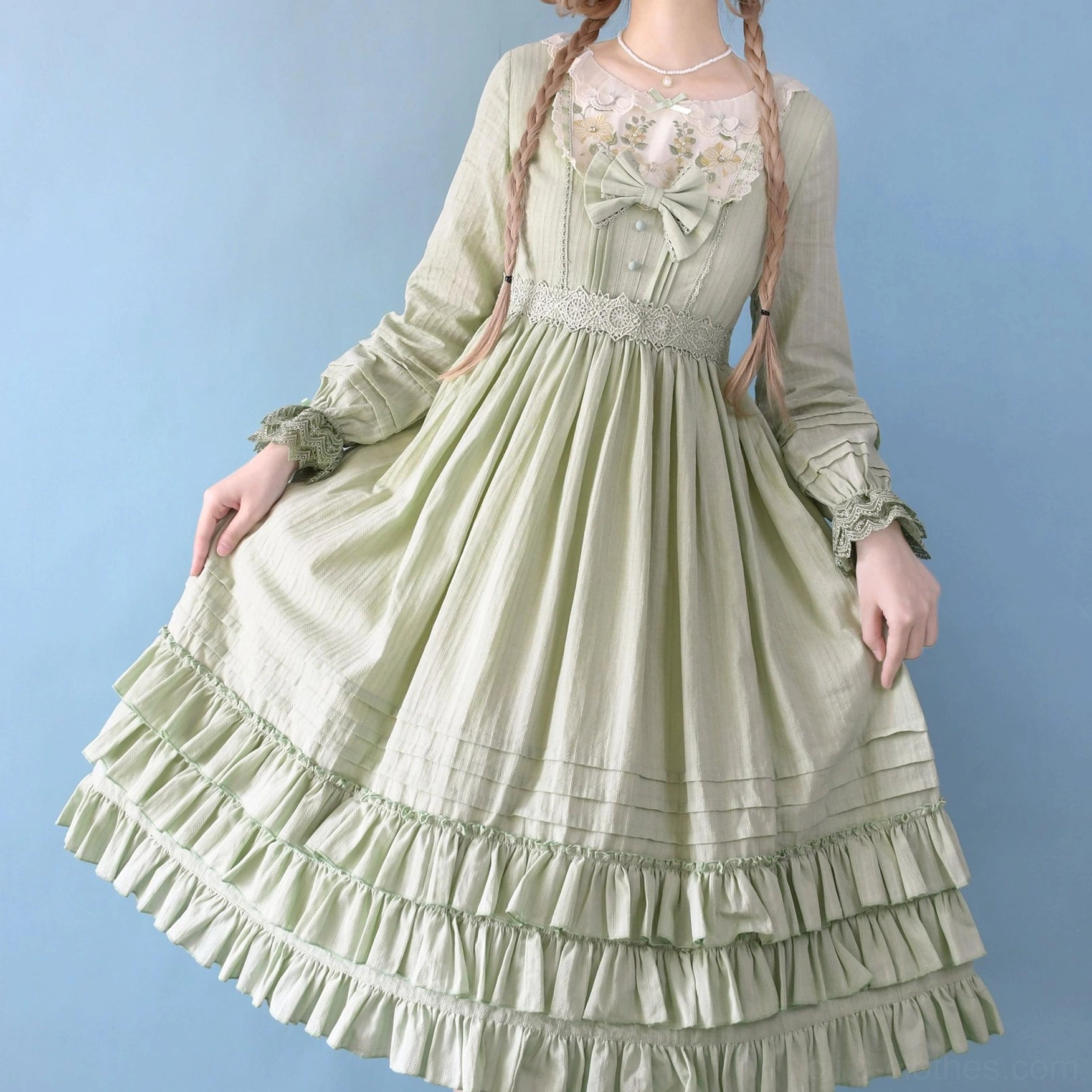 Sage green Sweet Lolita embroidered OP dress half-body shot showing long sleeves, ruffled tiered skirt hem, embroidered lace neckline, front waist bow design, subtle stripe jacquard texture detail