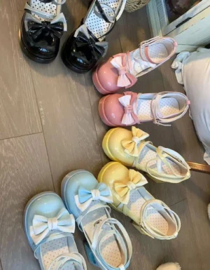 Sweet Lolita gradient patent leather Mary Jane platform heels with heart cutout block heel and bow ankle strap, displayed flat lay overhead view showing four gradient color variants in pink, light yellow, peacock blue, and black