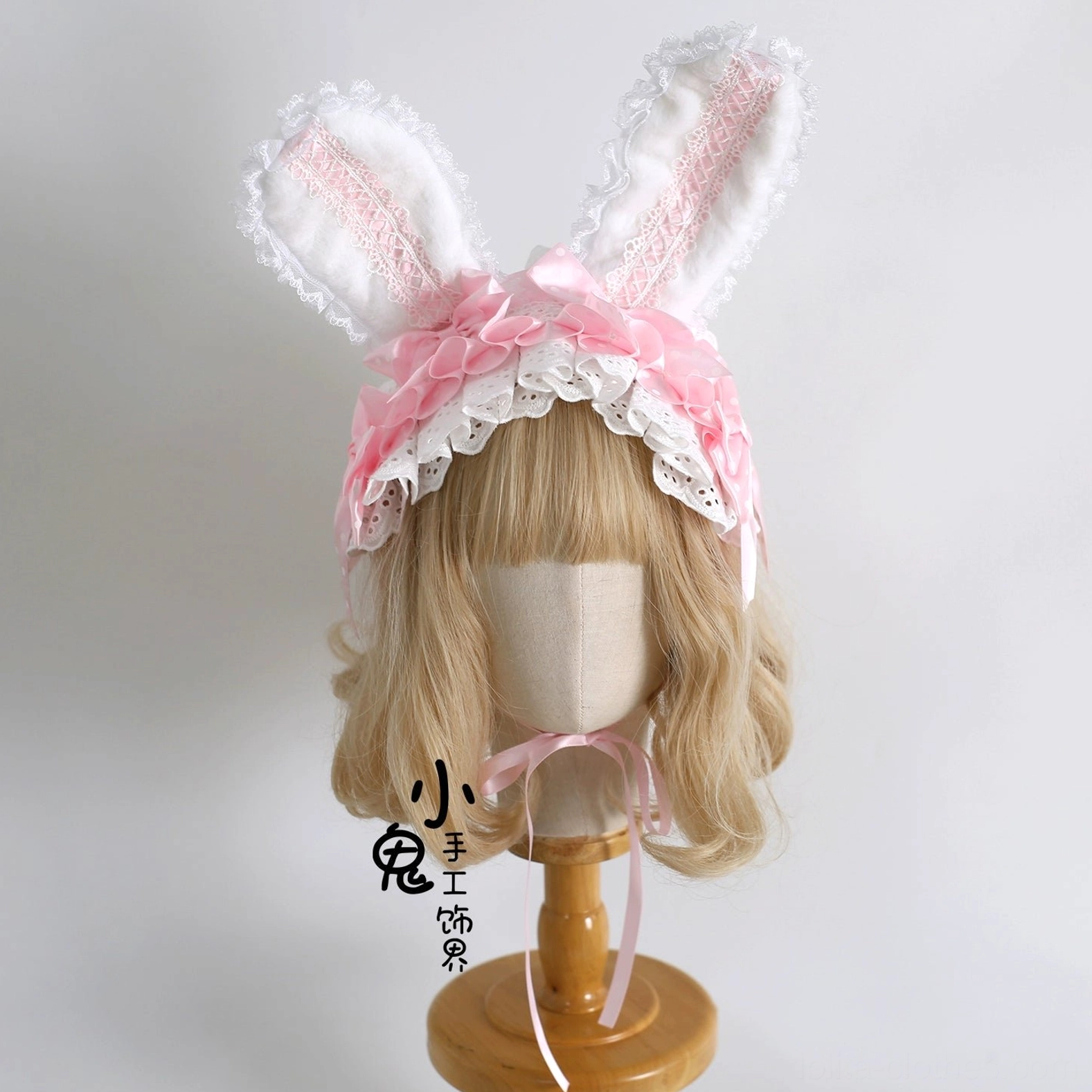 Light pink solid lace sweet lolita bunny ear hairband with white ruffled trim on blonde wig mannequin