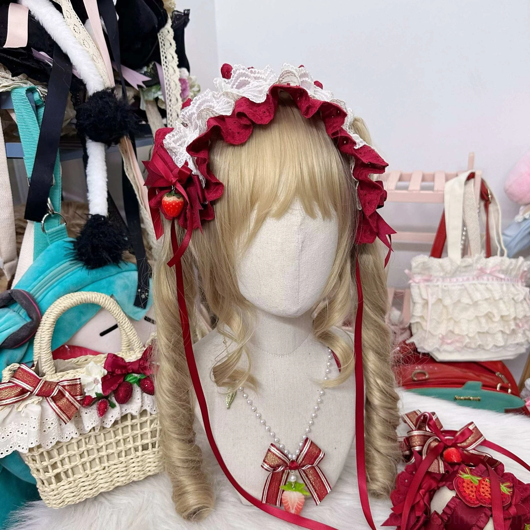Sweet lolita headband hair accessory set on mannequin with ruffled wine red lace trim strawberry decorations matching bow neck clip and straw bag
