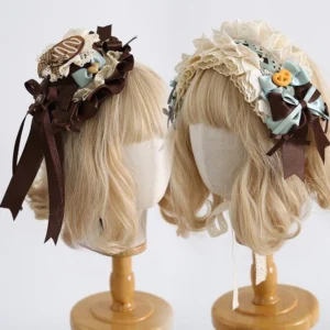Two matching sweet lolita hair accessories displayed side-by-side on mannequin heads showing ruffled headband and small top hat with coordinated candy and bow design