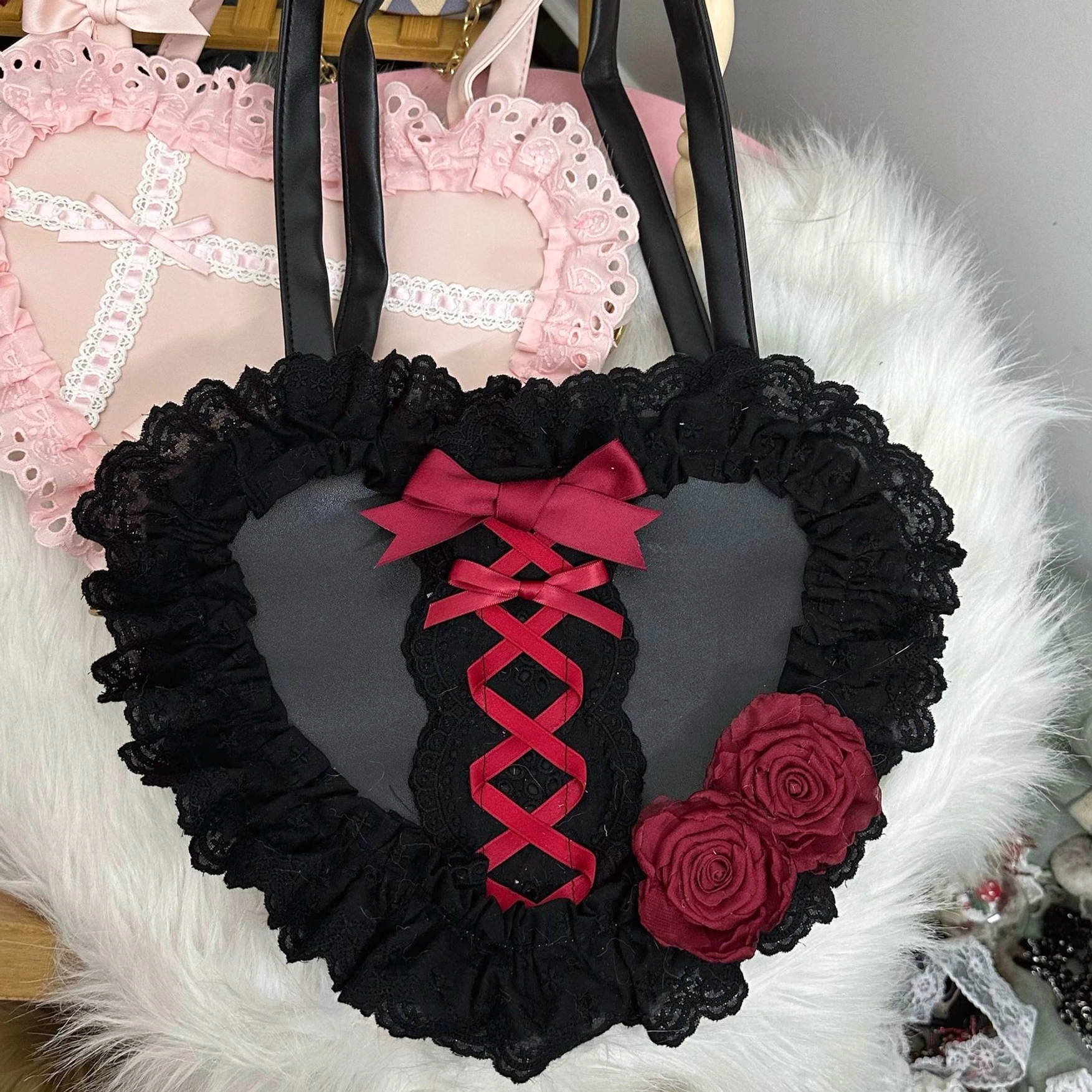 sweet lolita heart-shaped lace handbag black red variant flat lay display with ruffled lace border on white fur backdrop