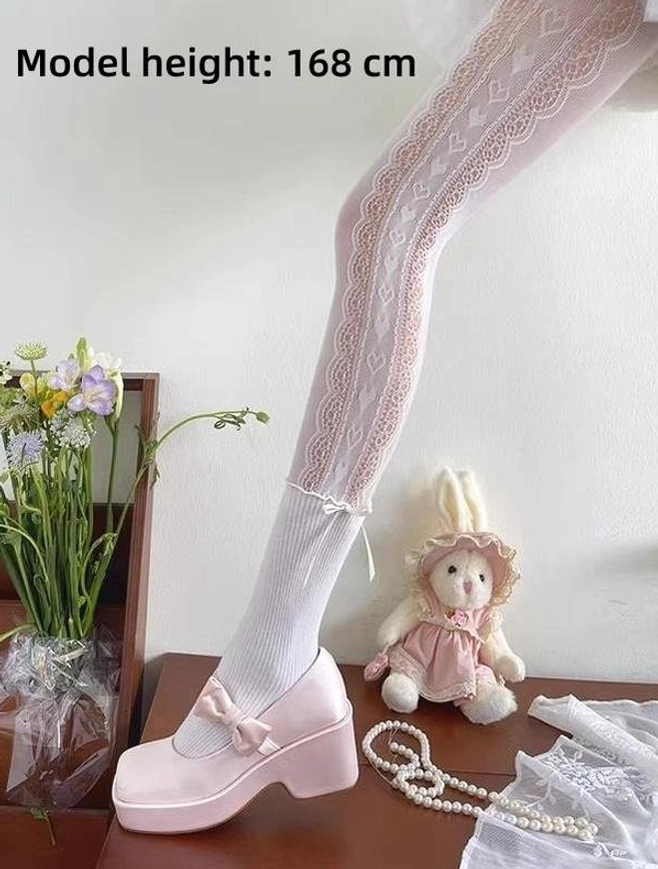 Sweet lolita heart lace patchwork pantyhose side view single leg showing heart-shaped lace patterns on thigh ankle bow decoration pink platform shoes