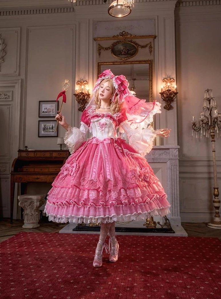 Sweet lolita one-piece hime sleeve dress full-body front indoor view in European retro palace room, model wearing matching headdress holding magic wand, voluminous pink skirt with delicate lace hem