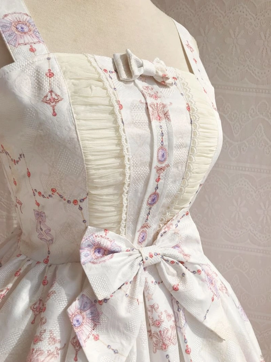 Close-up detail shot of sweet lolita JSK bodice showing off-white base delicate embroidery prints pleated cream trim small central bow and large front waist bow