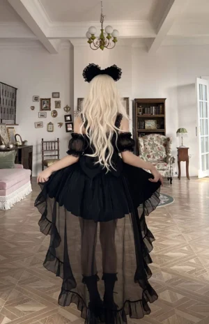 Black off-shoulder sweet Lolita high-low JSK dress full back view featuring sheer black tulle train, off-shoulder puff sleeves, ruffled hem, lace accents, and pearl details with vintage European interior backdrop