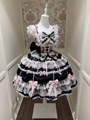 Black and white sweet lolita JSK dress with pink bow trims and checkered bodice, displayed on mannequin in vintage fitting room showing layered lace ruffles