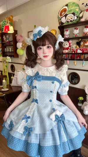 Sweet Lolita JSK dress set full-body front view worn by model in cozy doll-themed bedroom, featuring sky-blue polka dot dress with ruffled trims and multiple blue bow decorations, vintage plush toy collection background