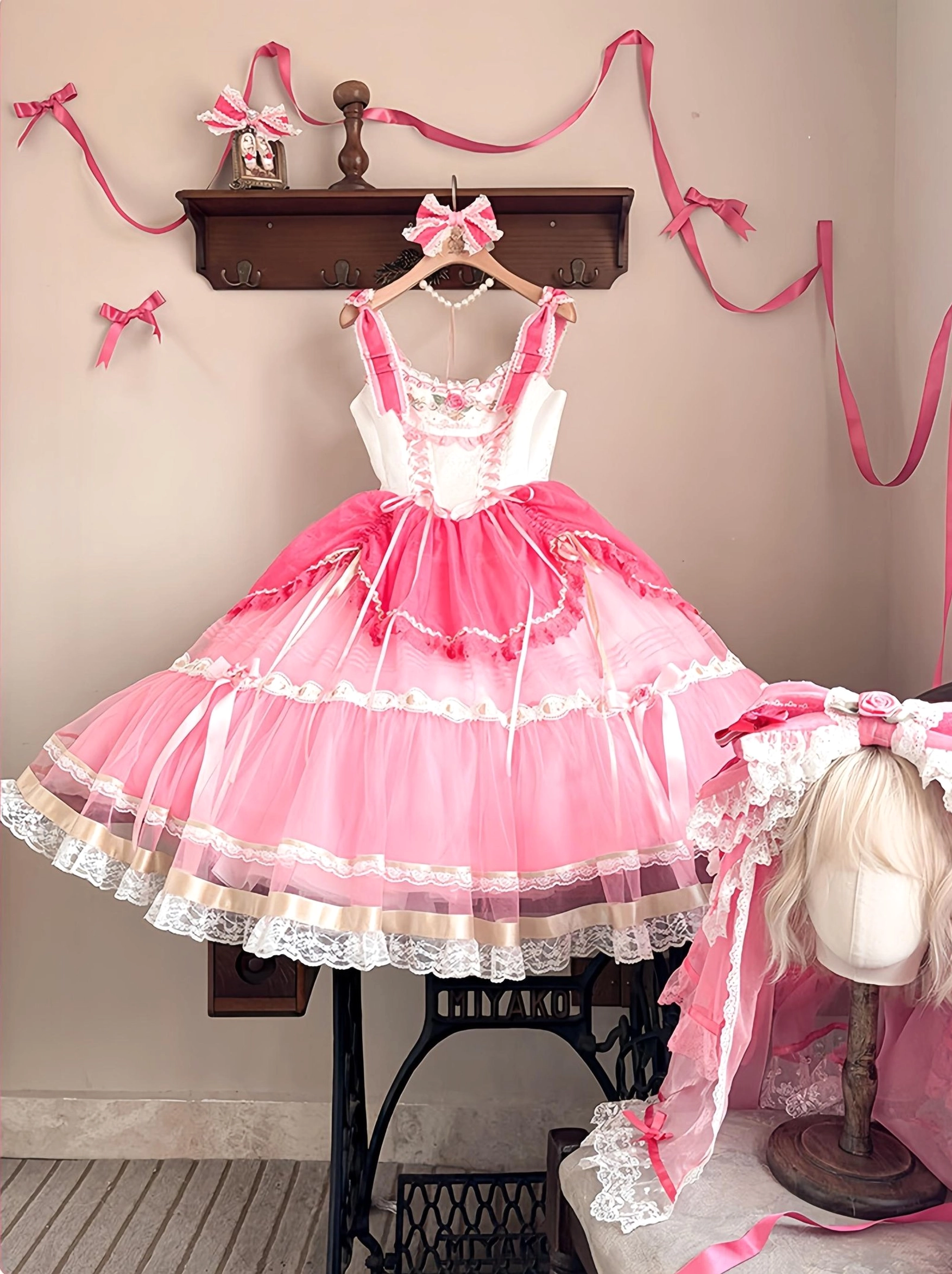 Sweet lolita jumper skirt JSK dress full front view hanging display, pink and off-white color scheme with layered tulle skirt and lace edge, matching headdress on mannequin