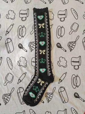sweet-lolita-knee-high-cotton-socks-black-base-mint-green-beige-crown-bow-heart-prints-scalloped-ruffled-cuff-flat-lay-top-down-view