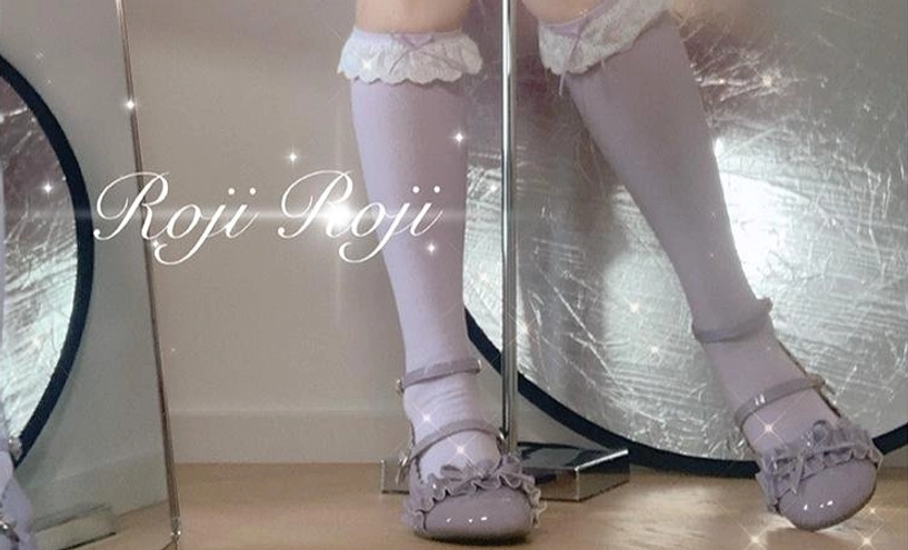 Sweet lolita knee-high socks with white lace trim and bow details worn in authentic lolita fashion coordinate with platform shoes and frilly dress complete outfit styling