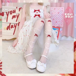Lolita girl wearing ethereal nude sheer knee socks with red bow heart motifs paired with white bow Mary Jane shoes and white sweet Lolita dress in soft bedroom setting