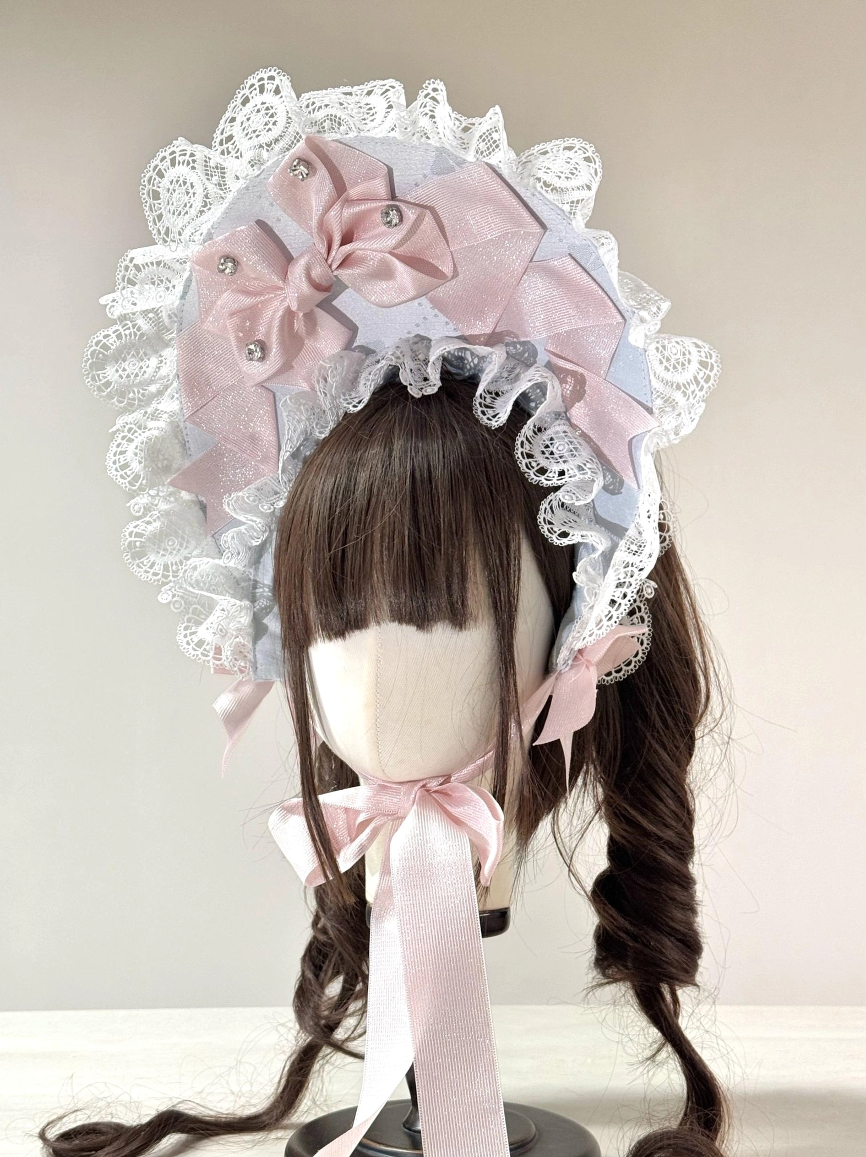 Sweet Lolita lace head bonnet with color-block design, pink and sky-blue satin bows, rhinestone embellishments, white ruffled lace border, light pink neck ribbons, pearl accents