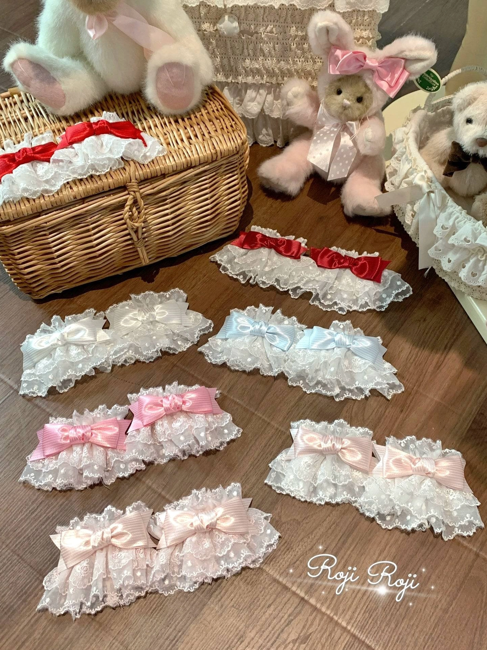 Sweet Lolita lace bow wrist cuffs collection display featuring multiple color variants on wooden table with teddy bears