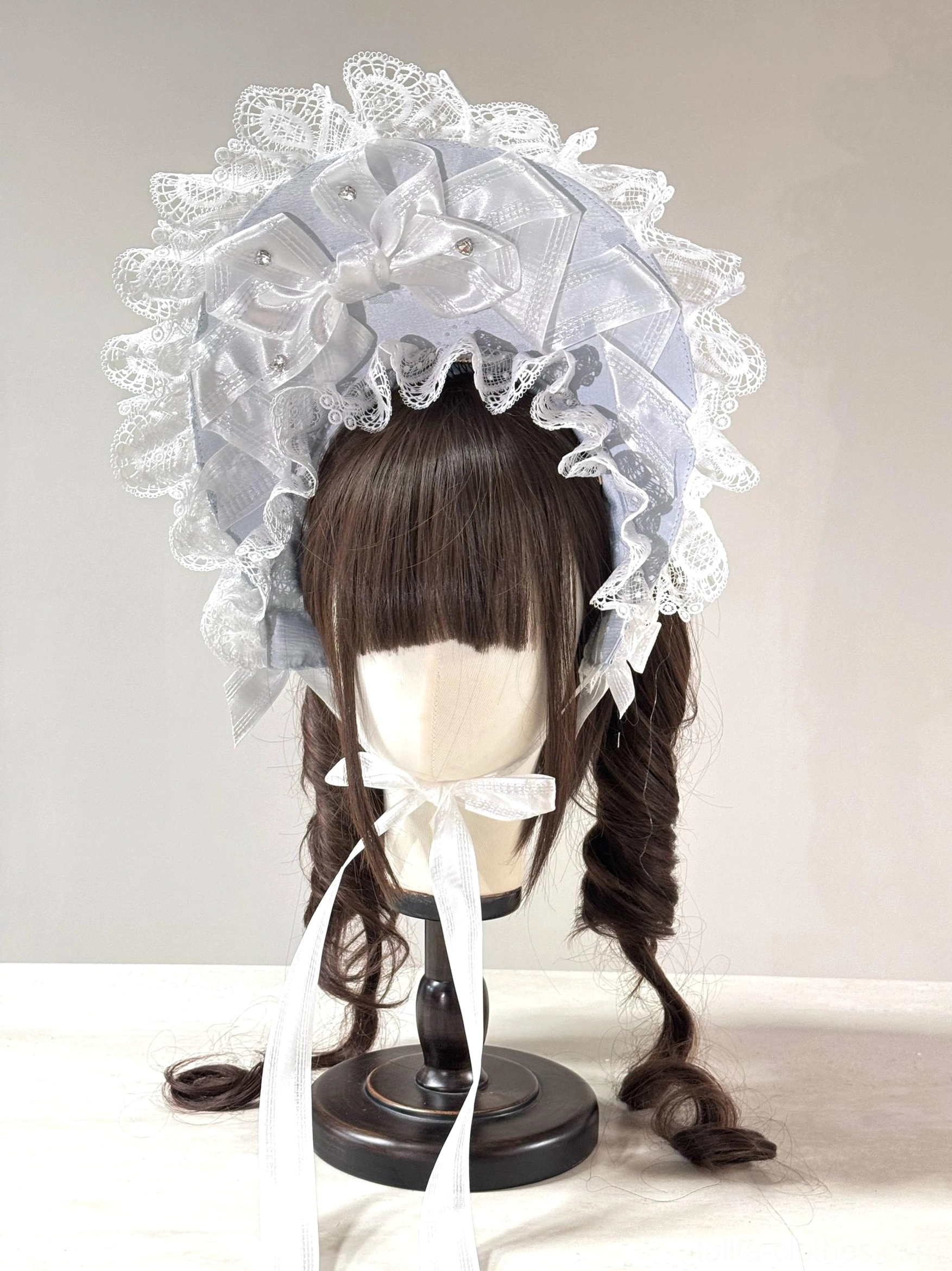 Sweet Lolita lace head bonnet in light gray satin, white ruffled lace edging, delicate white satin bow, long white neck ribbons, pearl decorations on fabric, mannequin display
