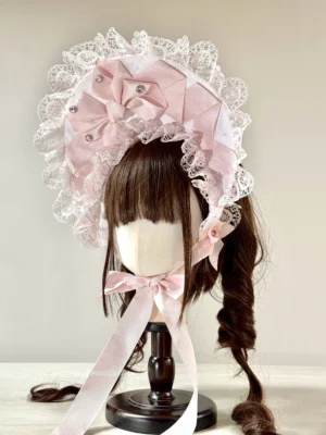 Sweet Lolita lace head bonnet featuring white base, light pink satin bows, sparkling rhinestone accents, delicate ruffled lace edging, matching pink neck ribbons, and pearl decorations