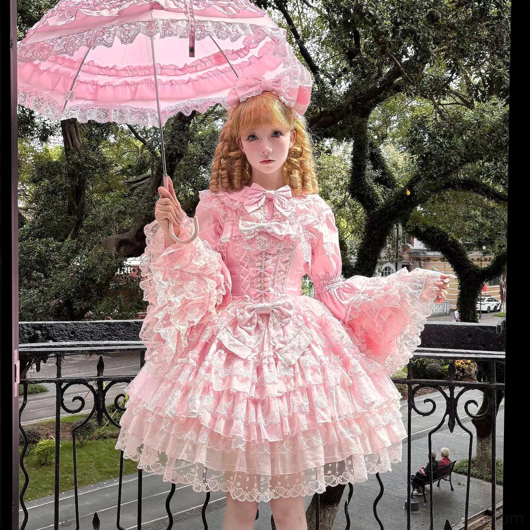 Long-sleeve Sweet Lolita princess dress with puffy lace trumpet sleeves, corset bodice adorned with bows, layered lace hem skirts, and matching parasol accessory