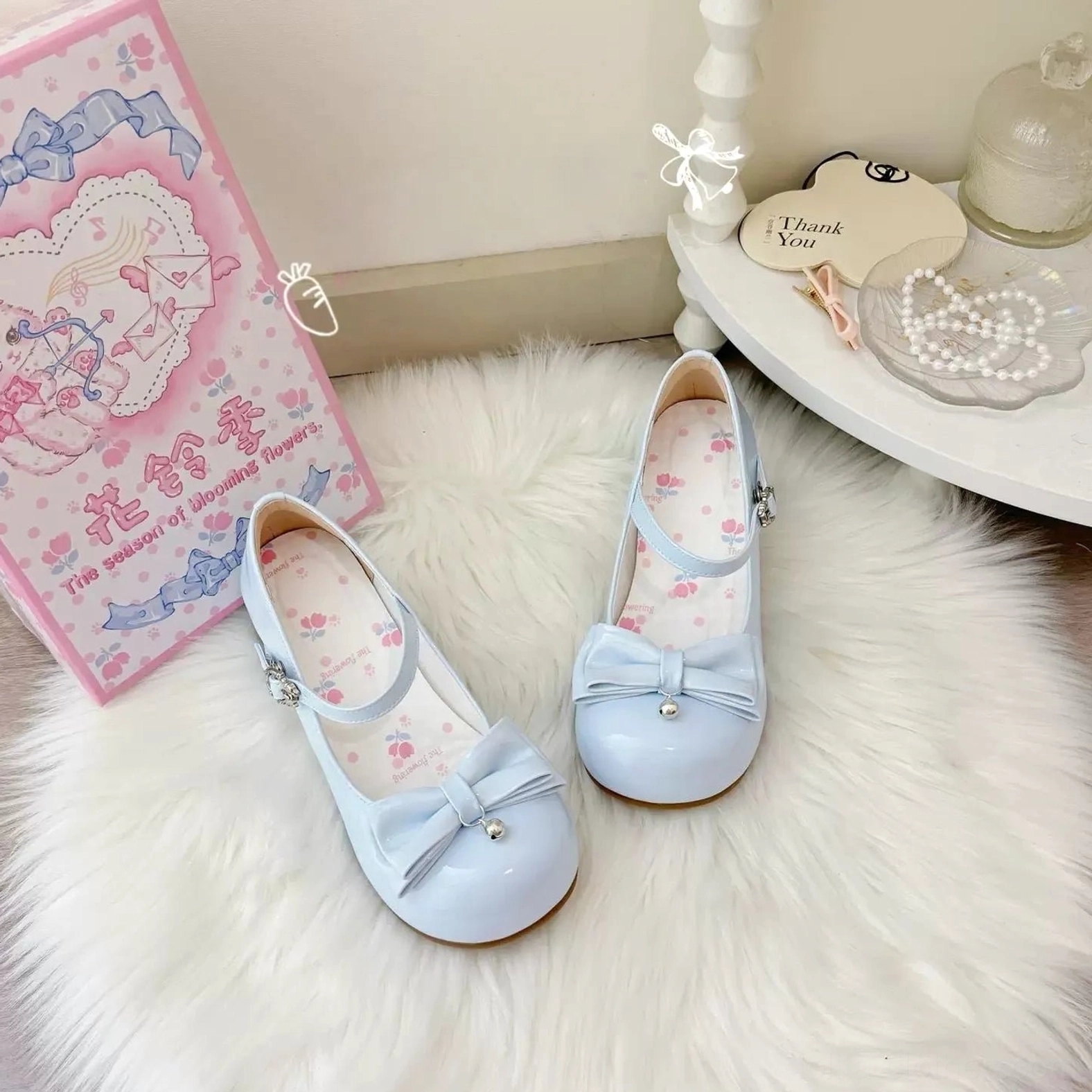 Sweet lolita Mary Jane heels bell pendant and front bow decoration close-up detail showing pearl accents, decorative bell charm with chiming quality, bow construction refinement, and overall aesthetic design philosophy in sweet lolita footwear
