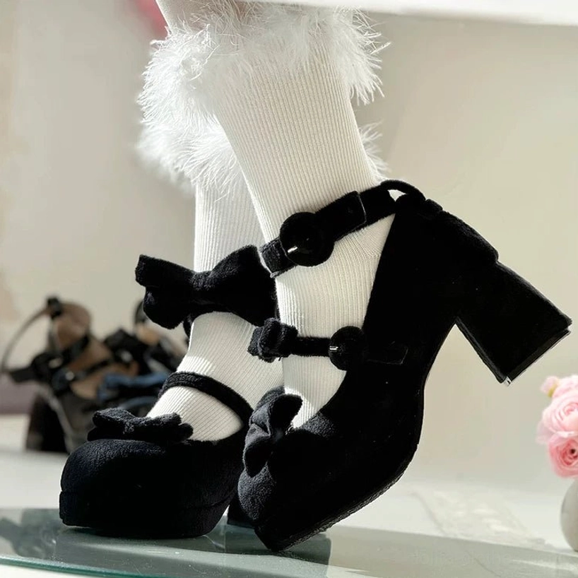 Black velvet sweet lolita chunky heel mary jane shoes with detachable ankle bows displayed on glass tray side view