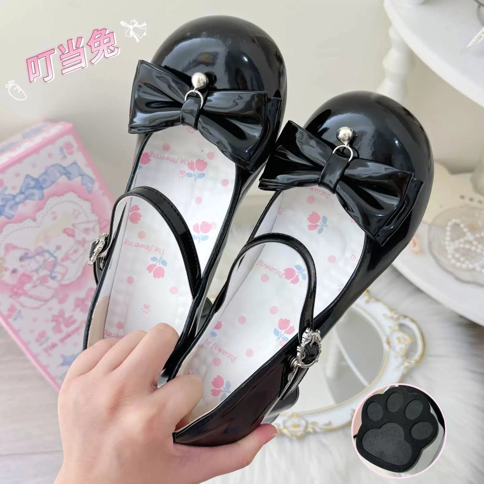 Sweet lolita Mary Jane heels product detail shot highlighting cat paw-shaped heel engineering and construction, showing how the distinctive feline heel shape creates leg-elongating visual effect, displayed with product packaging and coordinate styling accessories