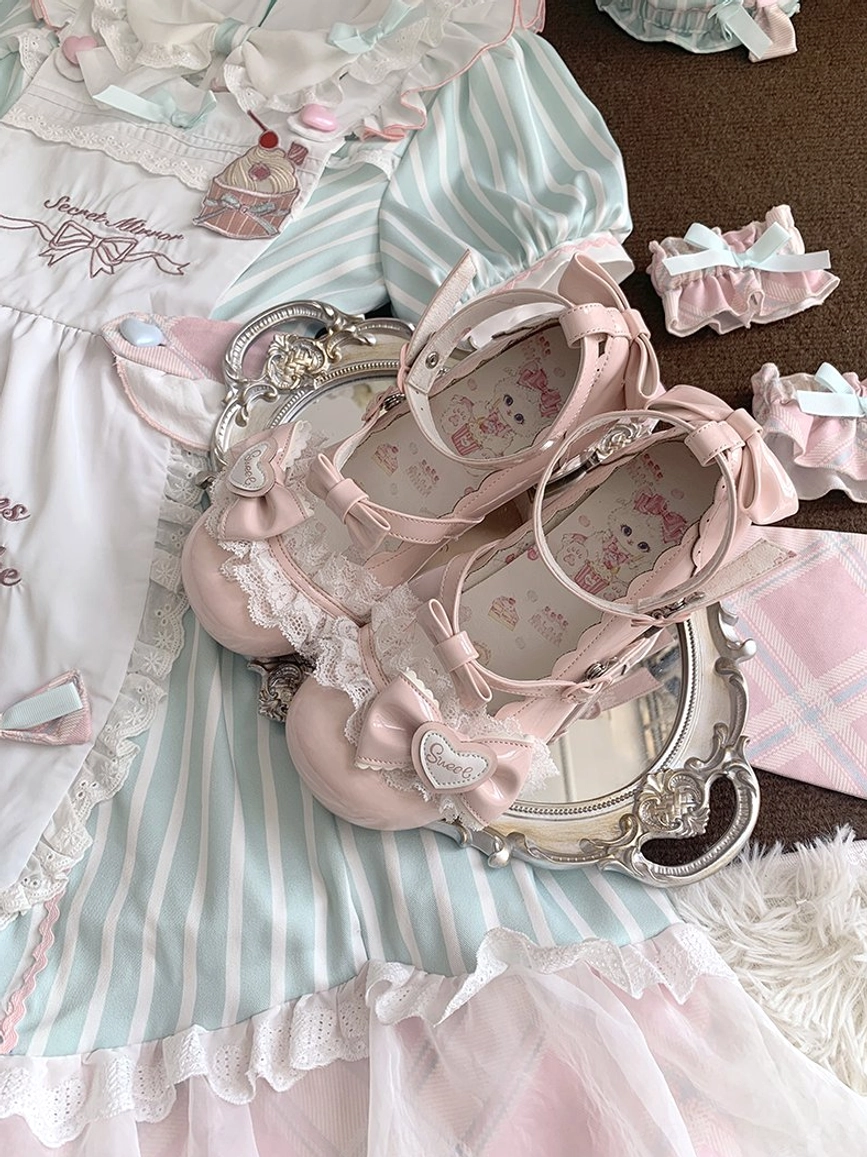Close-up overhead flat lay of sweet lolita mary jane heels showcasing inner insole block heel and lace bow decorations on silver tray with matching sweet lolita dress background
