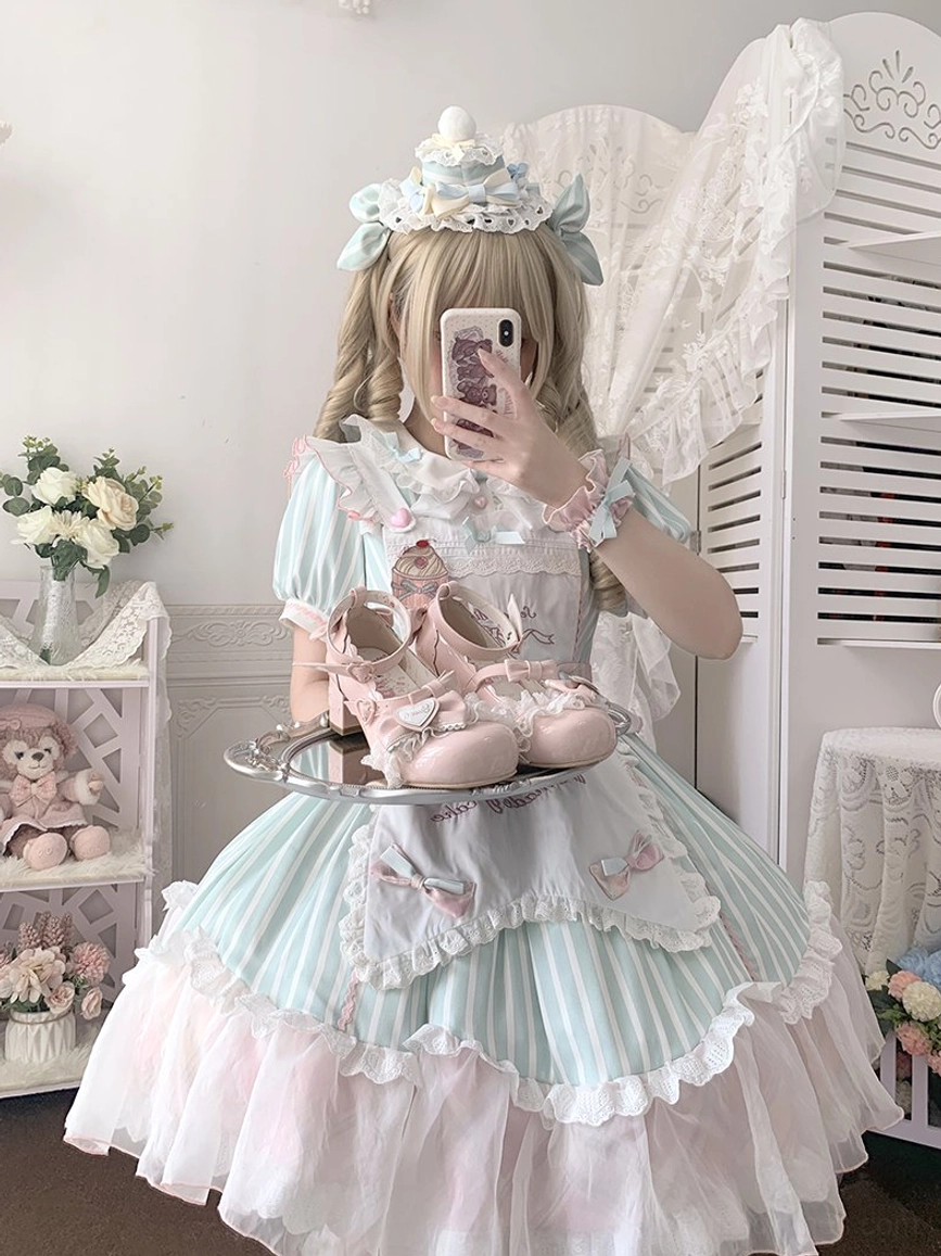Half-body mirror selfie angle of sweet lolita mary jane heels placed on silver tray with model wearing vintage lolita bedroom outfit in mint pink sweet lolita dress with matching bow decoration