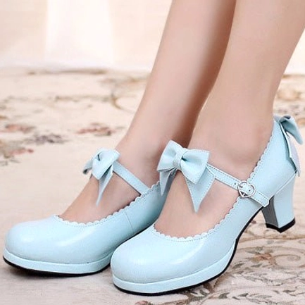 Light blue sweet Lolita Mary Jane platform heels on-foot photography displaying bow ankle strap heart buckle detail and chunky block heel on studio background