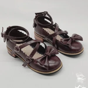 Burgundy patent leather sweet lolita Mary Jane shoes with crossover ankle straps and decorative heart-shaped buckles, showcasing the signature scalloped toe trim and low block heel design