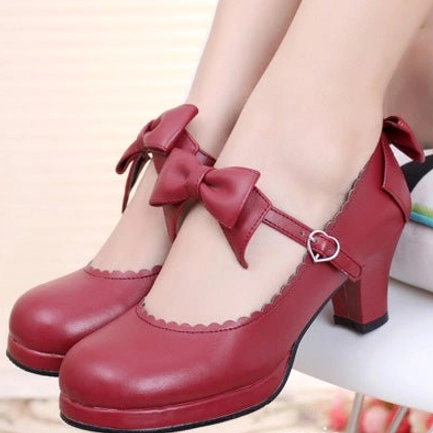 Burgundy wine red sweet Lolita Mary Jane chunky platform heels featuring double ankle bow and scalloped shoe opening with heart-shaped buckle on white cushioned furniture