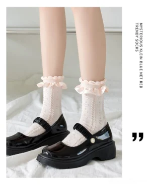 Sweet Lolita mid-calf socks with twisted hollow knit and ruffled lace ankle cuff, cream white color worn with black platform Mary Jane shoes on white bedding