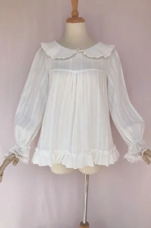 Sweet lolita milk white cotton long sleeve blouse with peter pan doll collar and double ruffle cuffs displayed on wooden mannequin front view