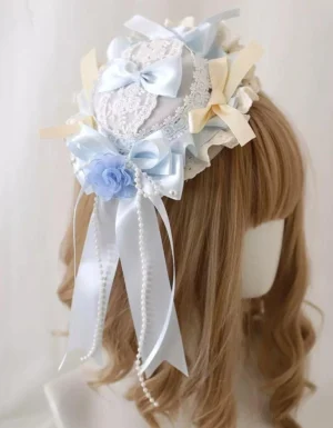 Sweet lolita mini top hat KC headdress with satin bows, fabric flowers, and pearl tassels - side view on mannequin with light brown curly wig