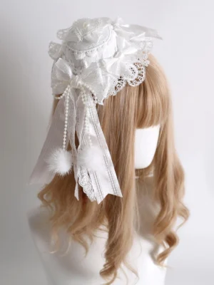 Sweet Lolita mini top hat with white ruffled lace trim, satin bow and pearl tassel details, back three-quarter view on blonde wig mannequin