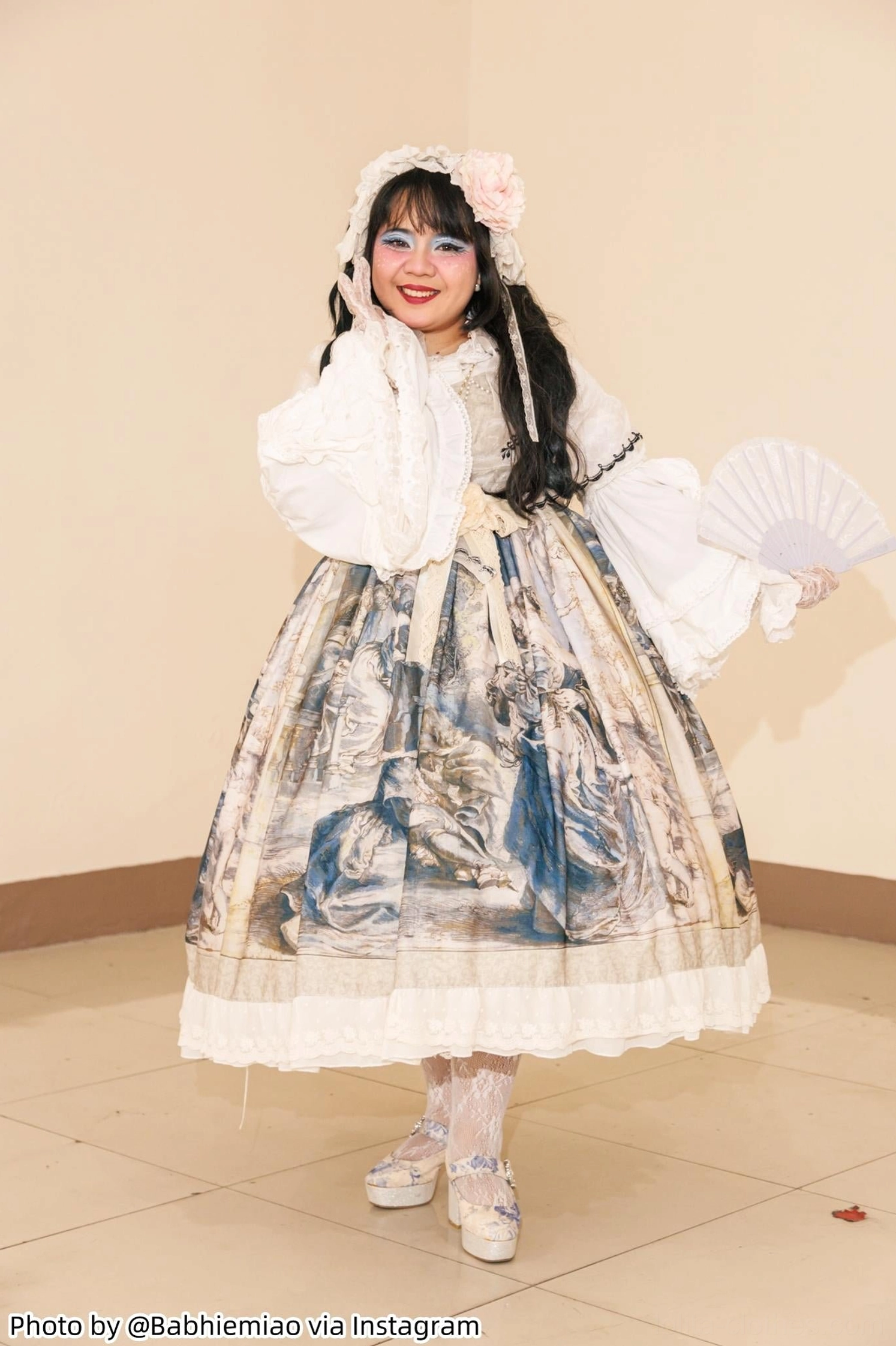 Sweet lolita female model full body front view wearing midi skirt with fluffy white petticoat, model holding paper fan, showing petticoat fluffiness effect, tiled floor background