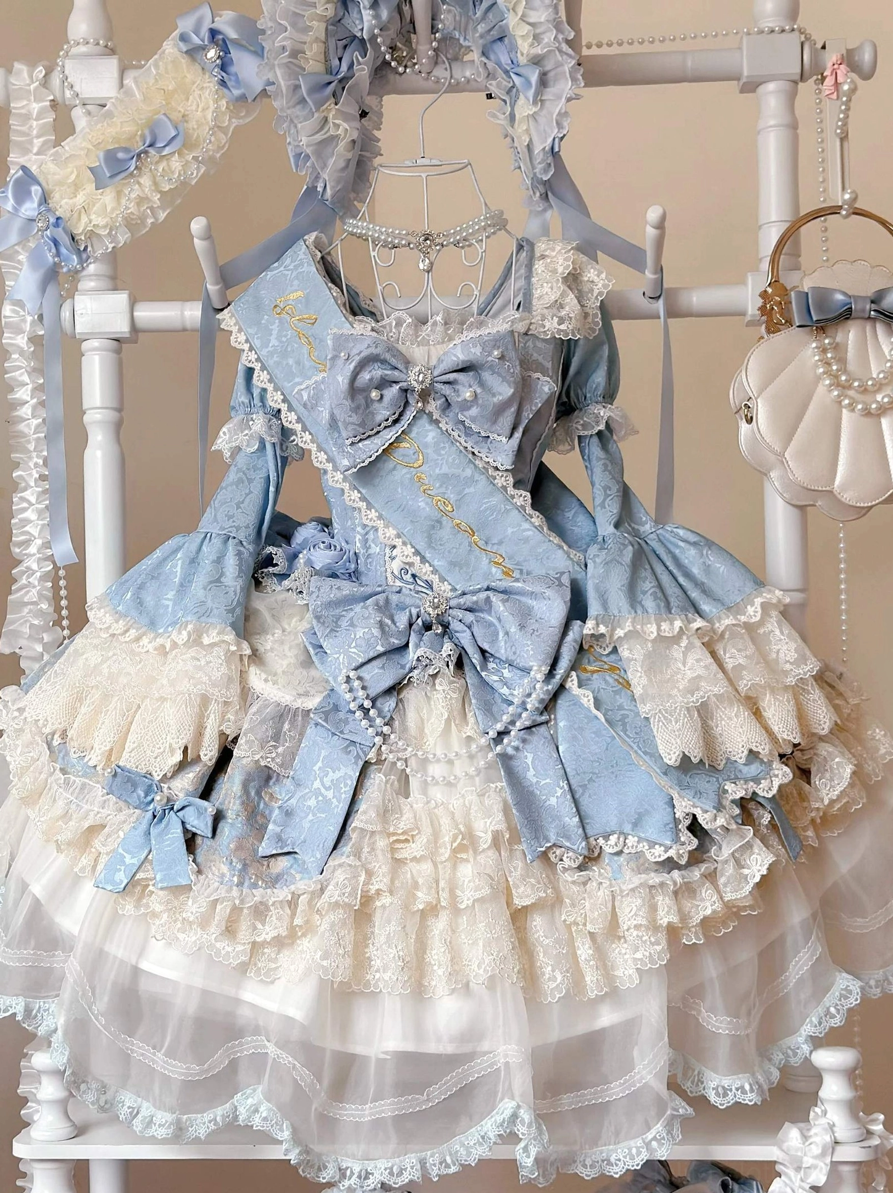 Sweet Lolita OP dress with detachable hand sleeves flat lay front display baby blue cream color multiple satin bows layered lace ruffles tulle skirt
