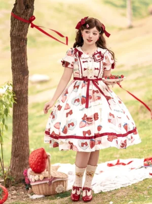 Sweet lolita one-piece dress front full view model holding strawberry dessert tray high-waisted A-line skirt ruffled doll collar matching red hair bows