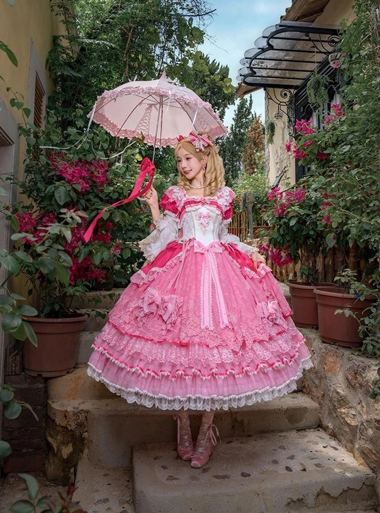 Sweet lolita one-piece dress full-body side outdoor view on villa garden stone steps, model holding vintage lace parasol, pink tulle skirt with lace hem and elegant off-white bust design