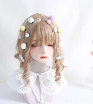 Sweet Lolita pompom hair clips in pastel colors clipped into curly blonde wig on BJD mannequin wearing lace collar blouse