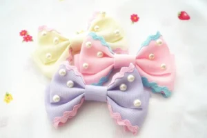 Sweet lolita pearl bow hair clips pastel colors scalloped trim faux pearls overhead flat lay view strawberry fabric background