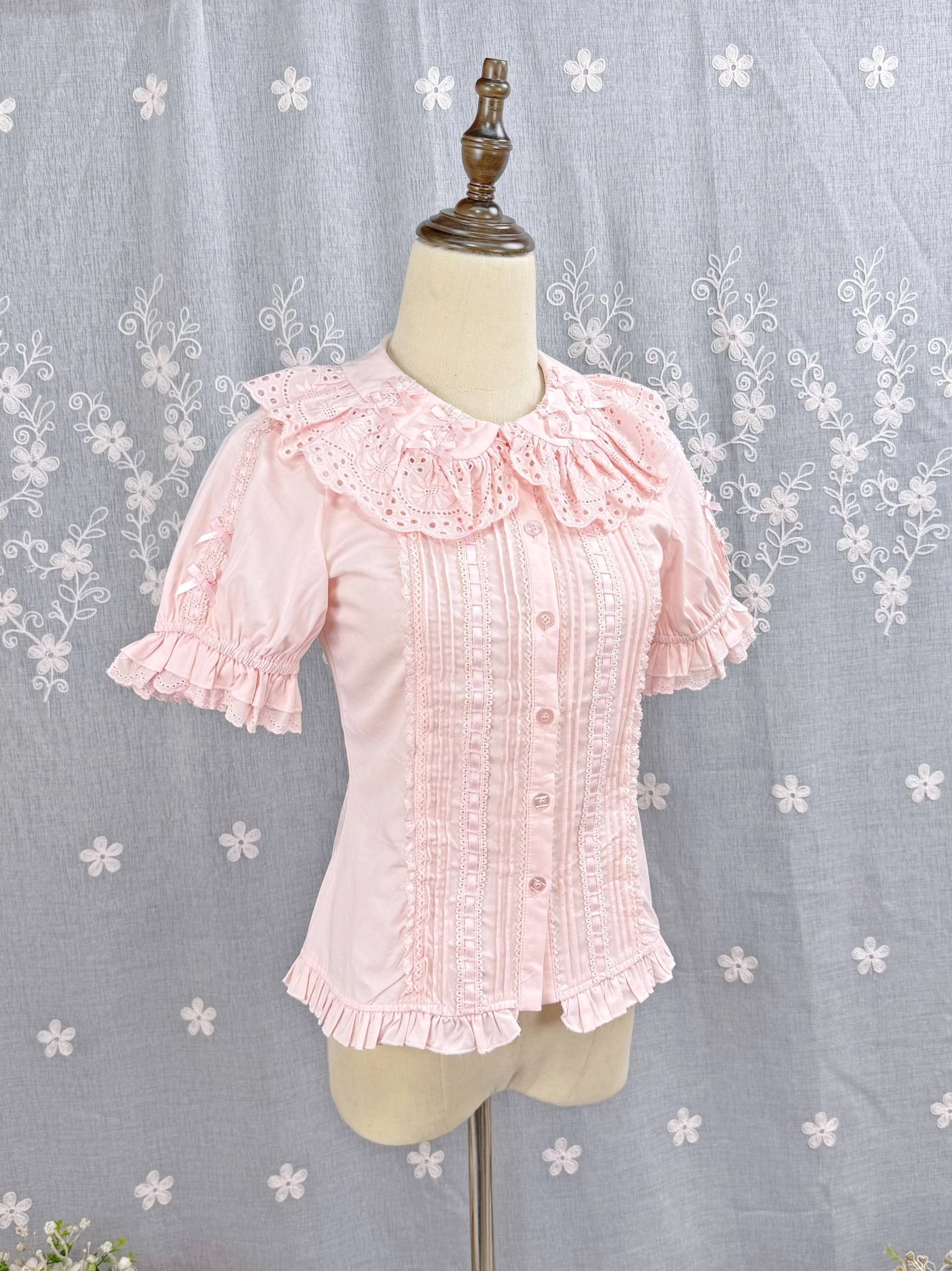 Sweet Lolita Peter Pan collar cotton blouse close-up detail showing embroidered hollow ruffled neckline and small bow accent