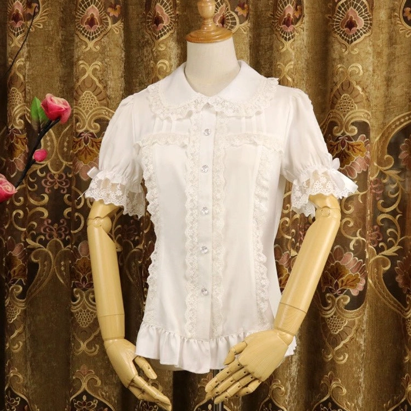 Milk white short-sleeve sweet lolita chiffon blouse with Peter Pan collar and lace trim, front view on dress mannequin, vintage embroidered backdrop