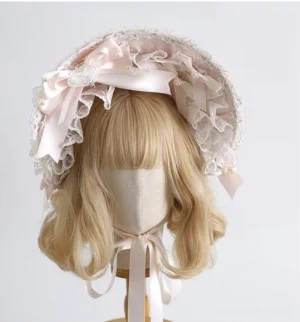 Sweet lolita pastel pink bonnet hat with ruffled lace trims white lace bows and satin hanging ribbons front view on mannequin head